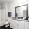 bathroom with a large mirror and walk-in shower
