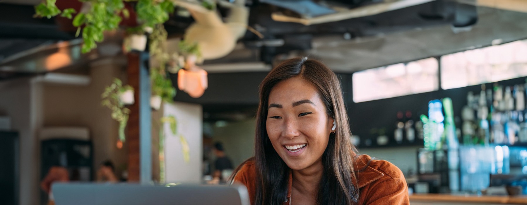 a woman smiling while working on laptop