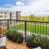 a balcony with a view of grass lawn and trees